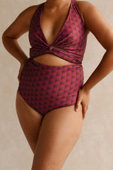 Woman wearing a burgundy bikini set with a geometric jewelled pattern.
