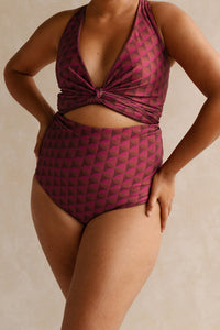 Woman wearing a burgundy bikini set with a geometric jewelled pattern.