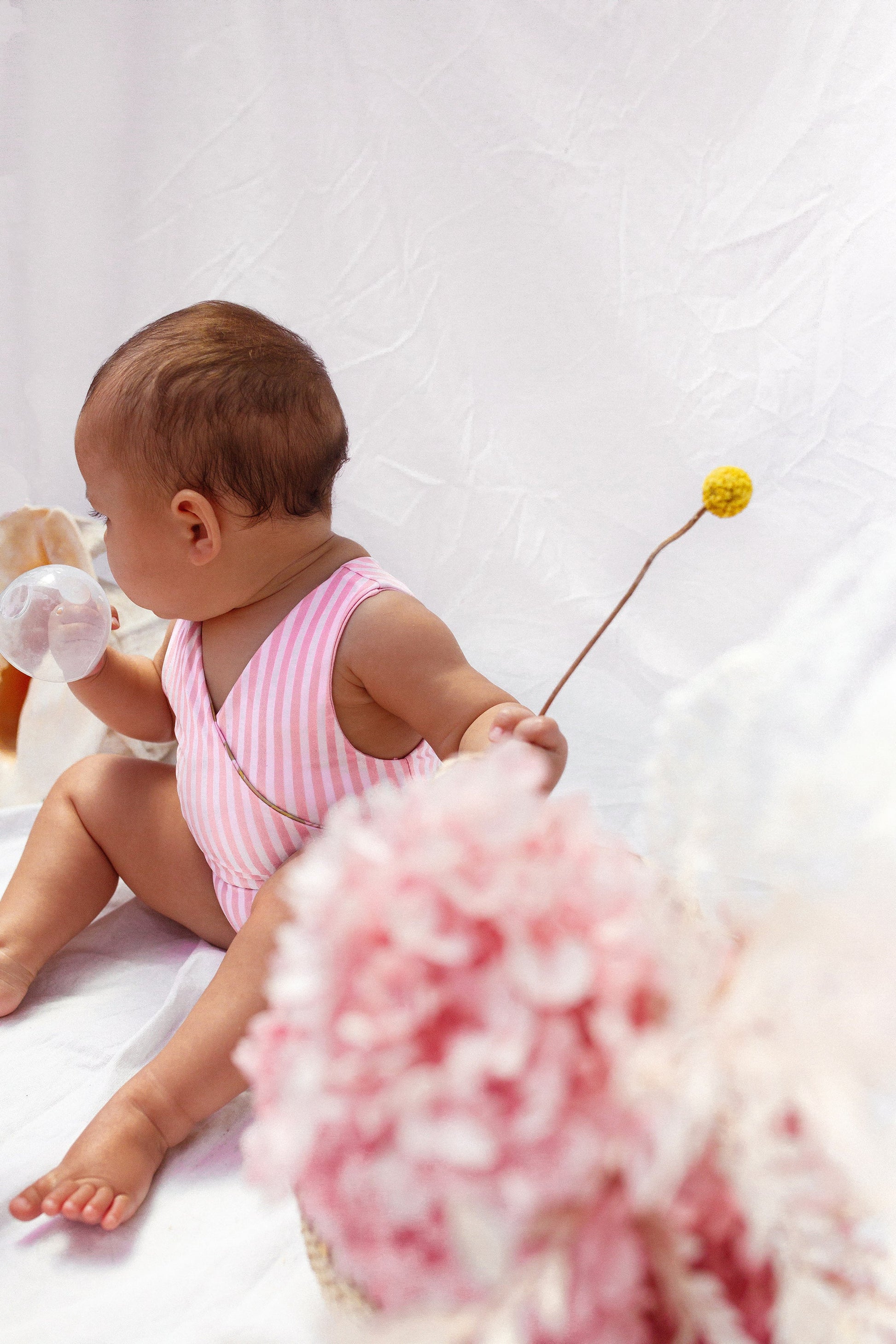 Baby in reversed pink and white stripe swimsuit