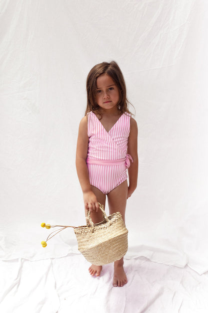 Girl in reversed pink and white stripe swimsuit with pink tie at waist