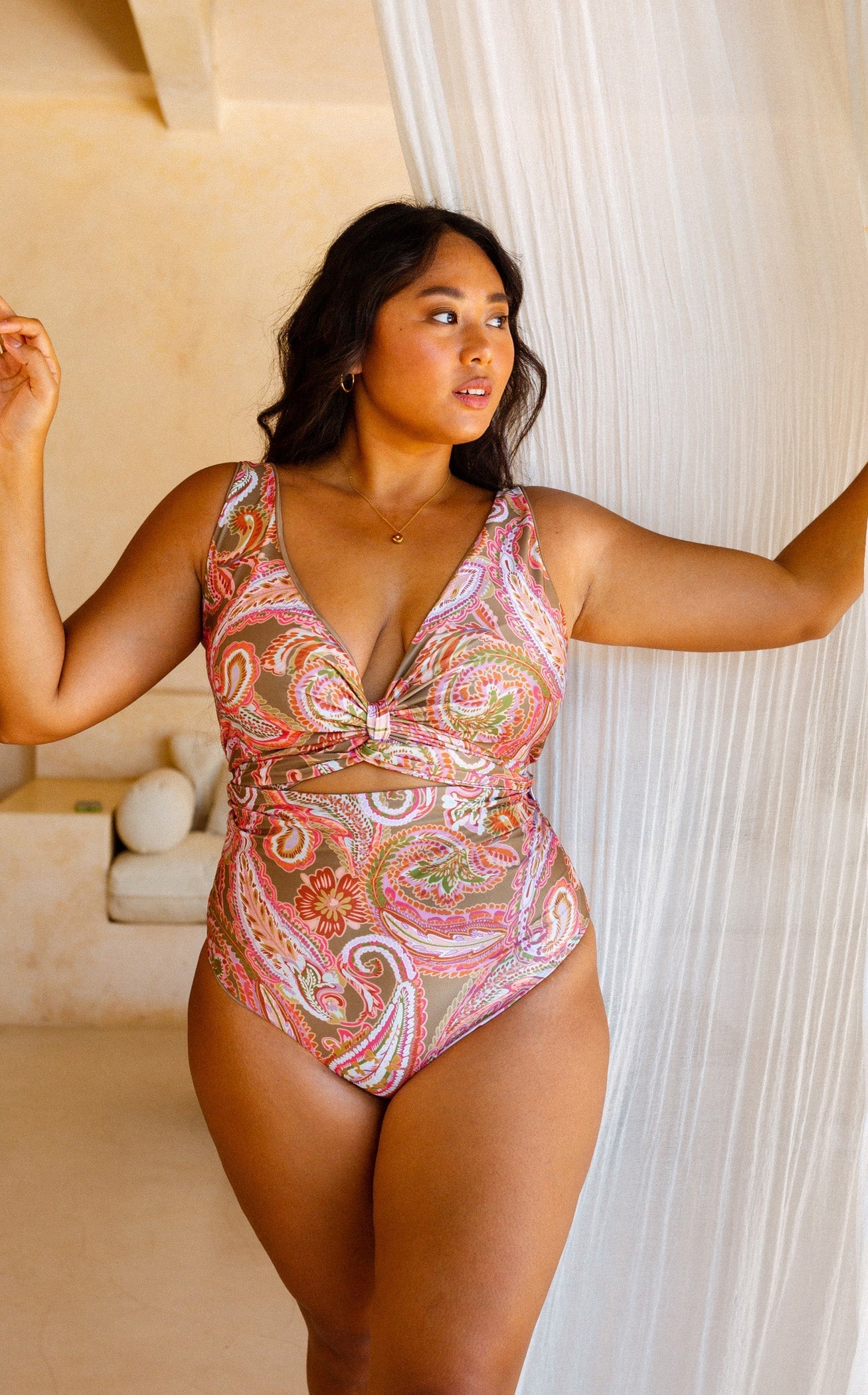 Woman posing by flowy curtain dressed in the shaping Barcelona bikini 