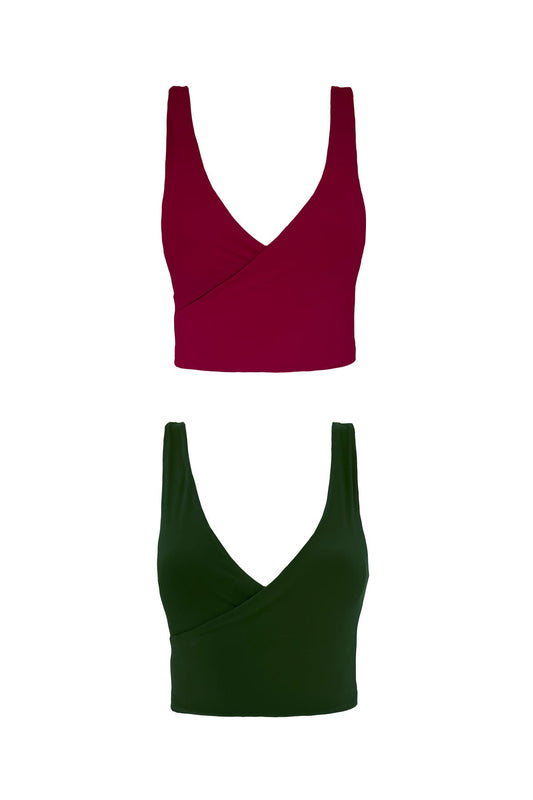 A product image showing each reversible side of the Gaia bikini top. One top shows the raspberry pink side, whilst the other features a complimentary deep green colour.