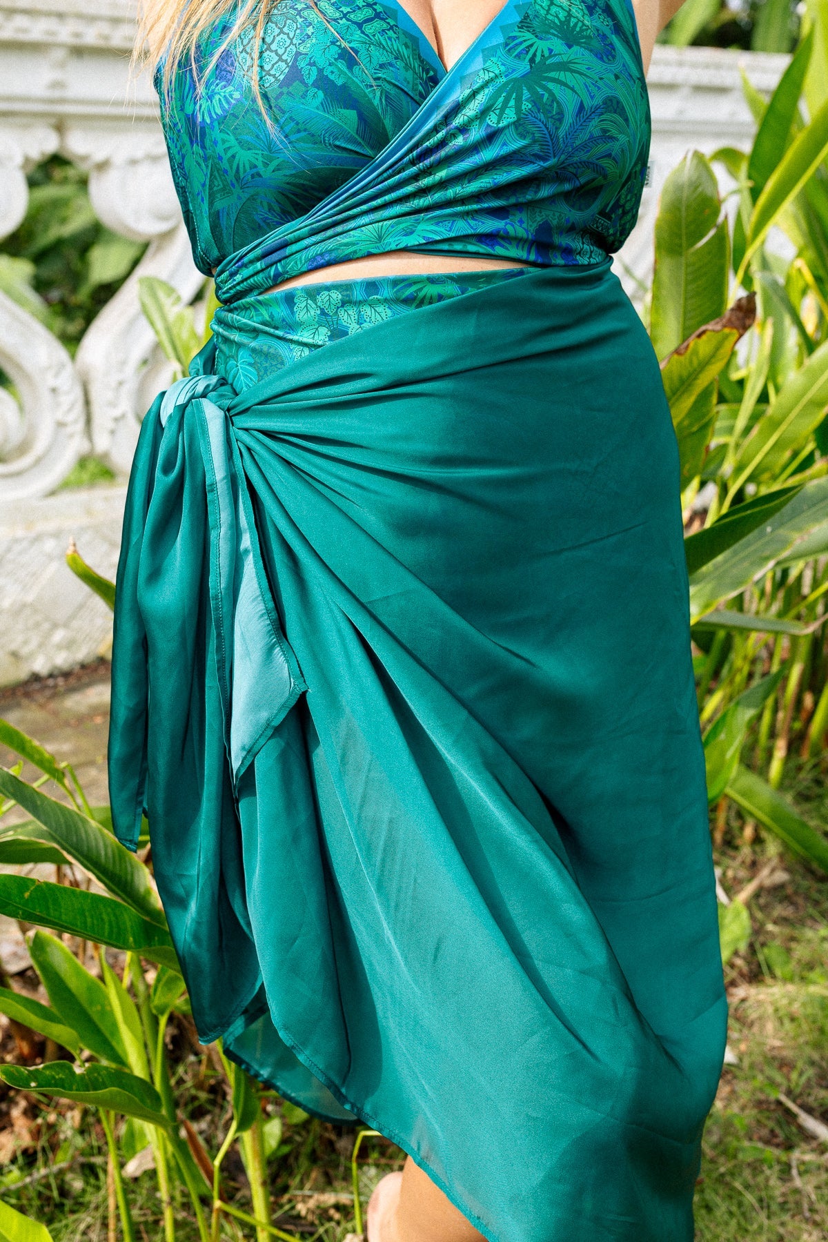 Close up of a woman with a jasmine green sarong tied at her hip.